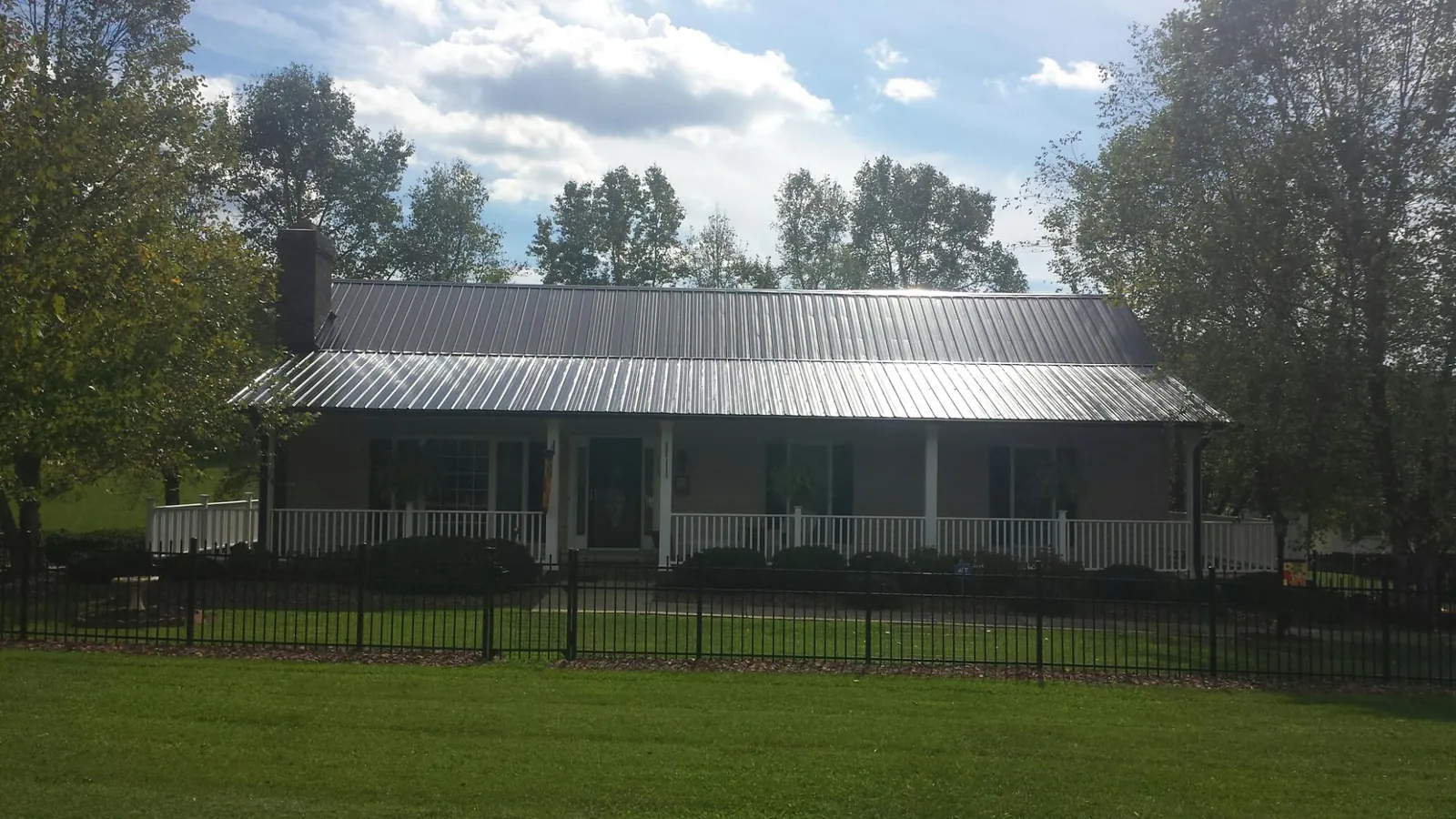 Gray metal roof on a brick ranch with a full width front porch — Gutter Guard Installation work by our crew in Nottingham