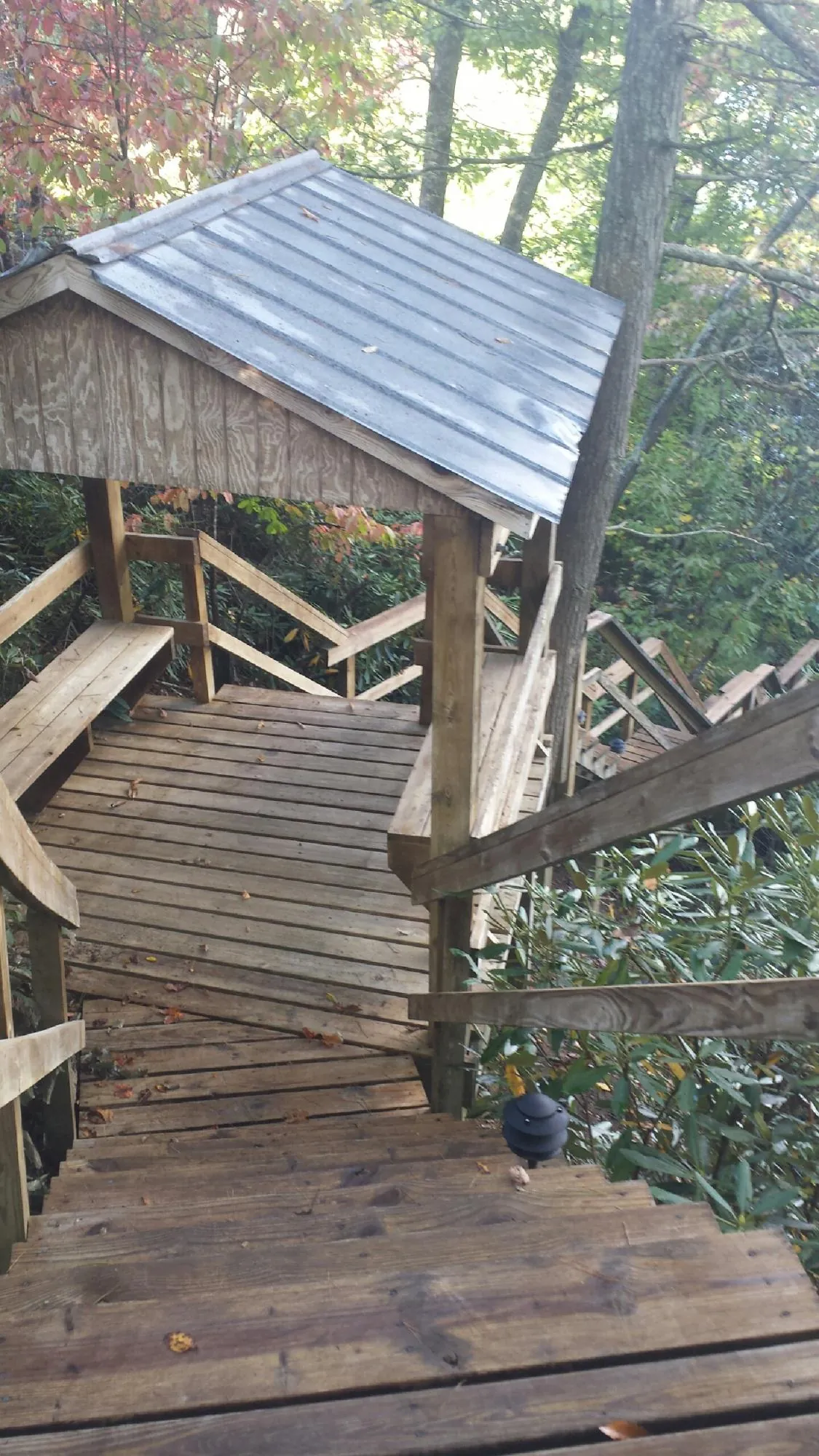 Metal roofed shelter over wooden steps on a wooded walkway — Skylight Repair & Installation work by our crew in Nottingham