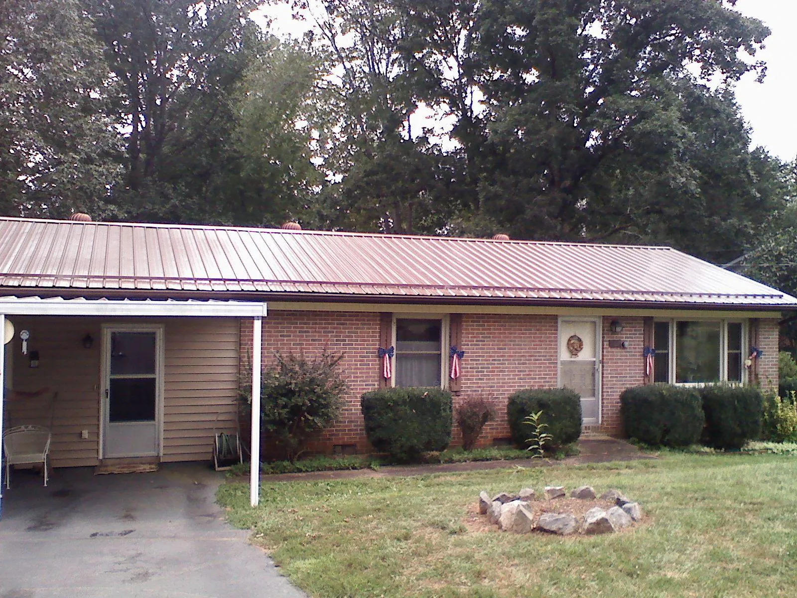 Bronze metal roof and carport on a brick ranch home — Roof Repair work by our crew in Nottingham
